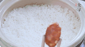 煮開后轉小火，當米飯出現小孔時，鋪上金字麻辣香腸。