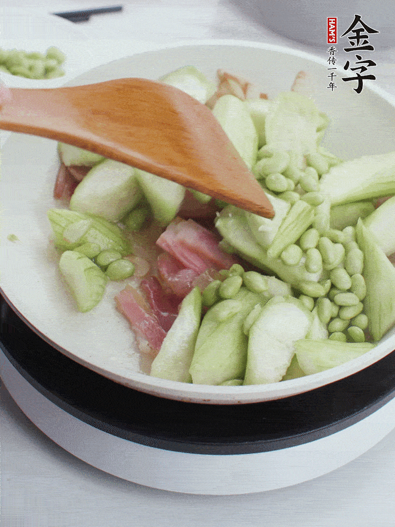 依次下絲瓜、青豆翻炒，炒至絲瓜打蔫縮小。