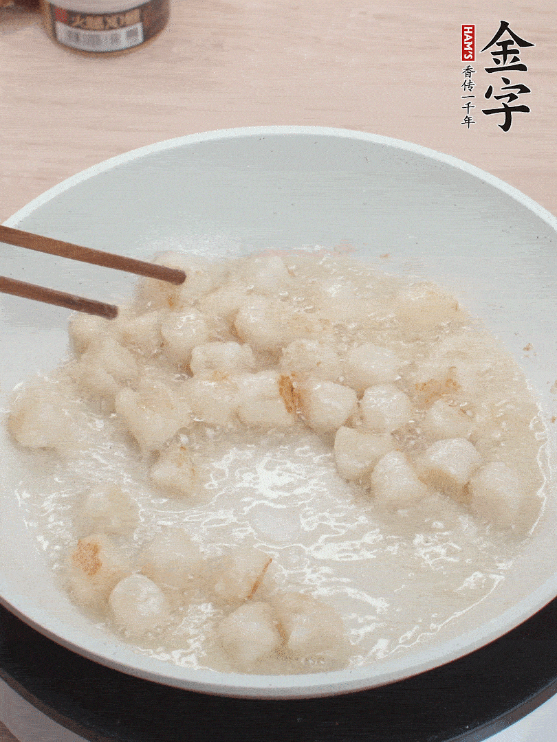 油溫4成熱，鮮貝蘸干淀粉下鍋煎，一面微黃后翻面。