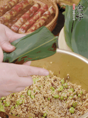 粽葉往下折，完全蓋住，兩側(cè)捏緊。